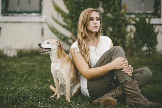 Woman and dog sitting peacefully in yard