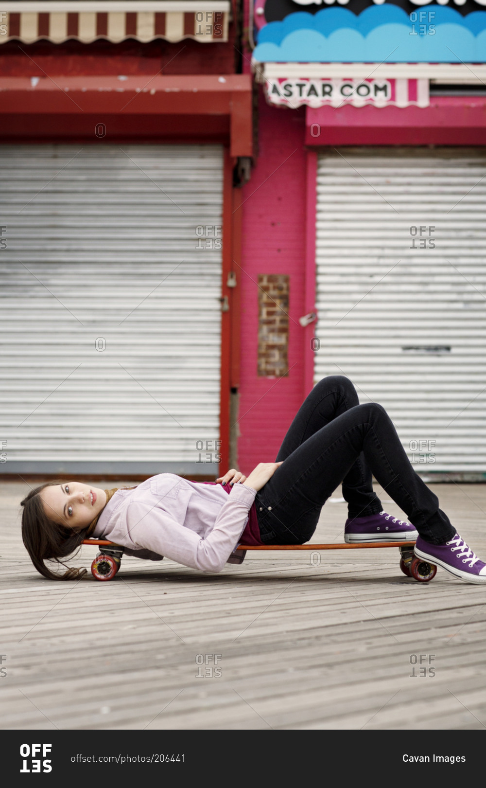 Young woman lying on skateboard