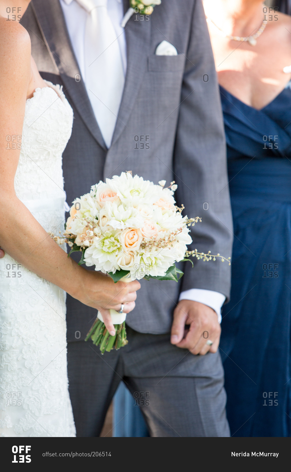 Bride holding a wedding bouquet next to the groom