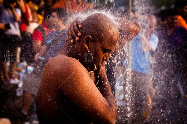 Gombak, Malaysia - January 20, 2011: Man showering and praying during Malaysia festival