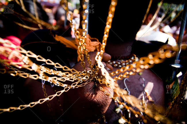 Golden kavadi chains in hand