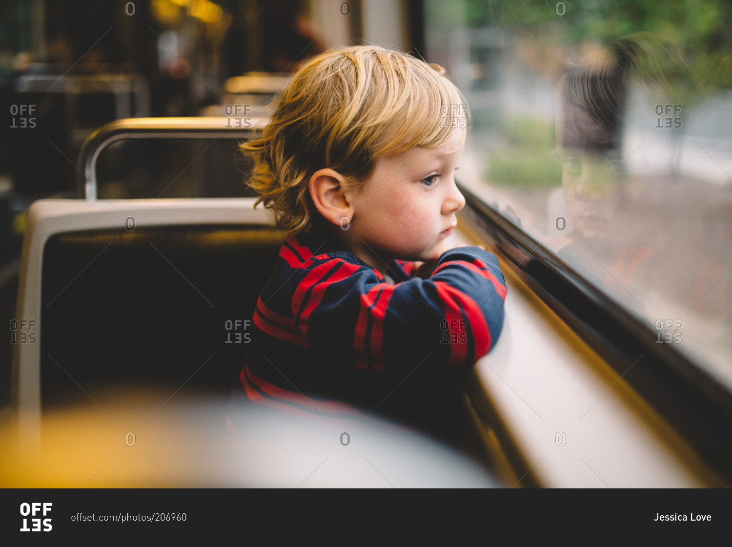 Little boy staring out the window of a train