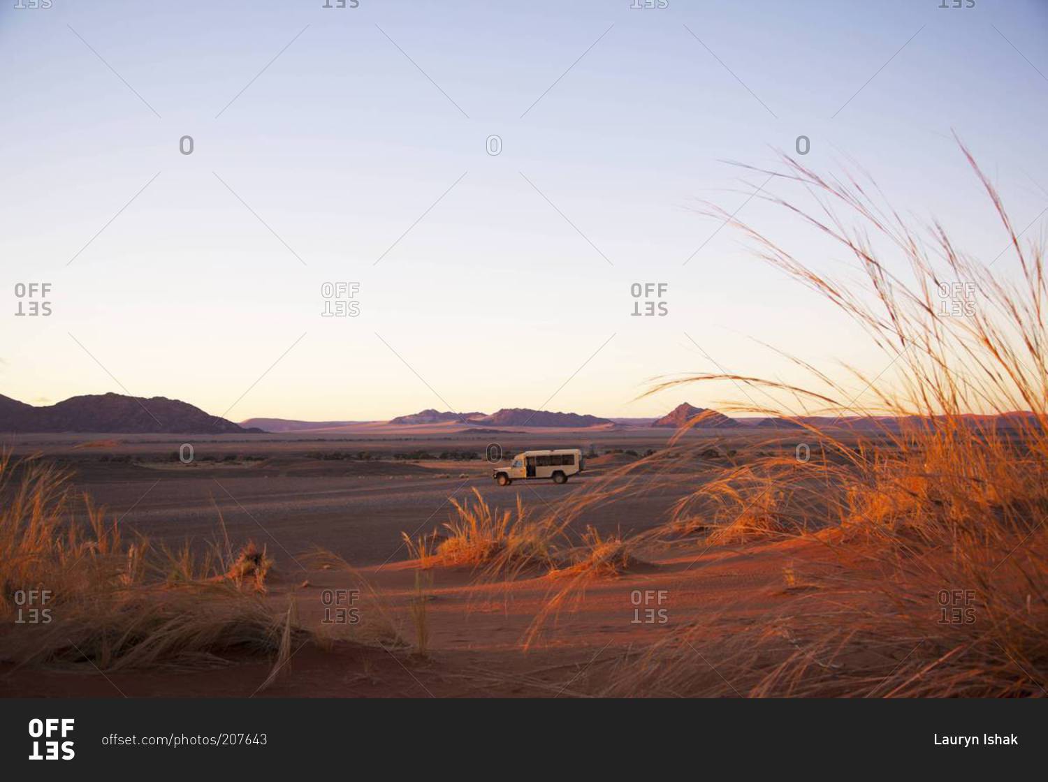 A safari van at sunrise in Sossusvlei, Namibia