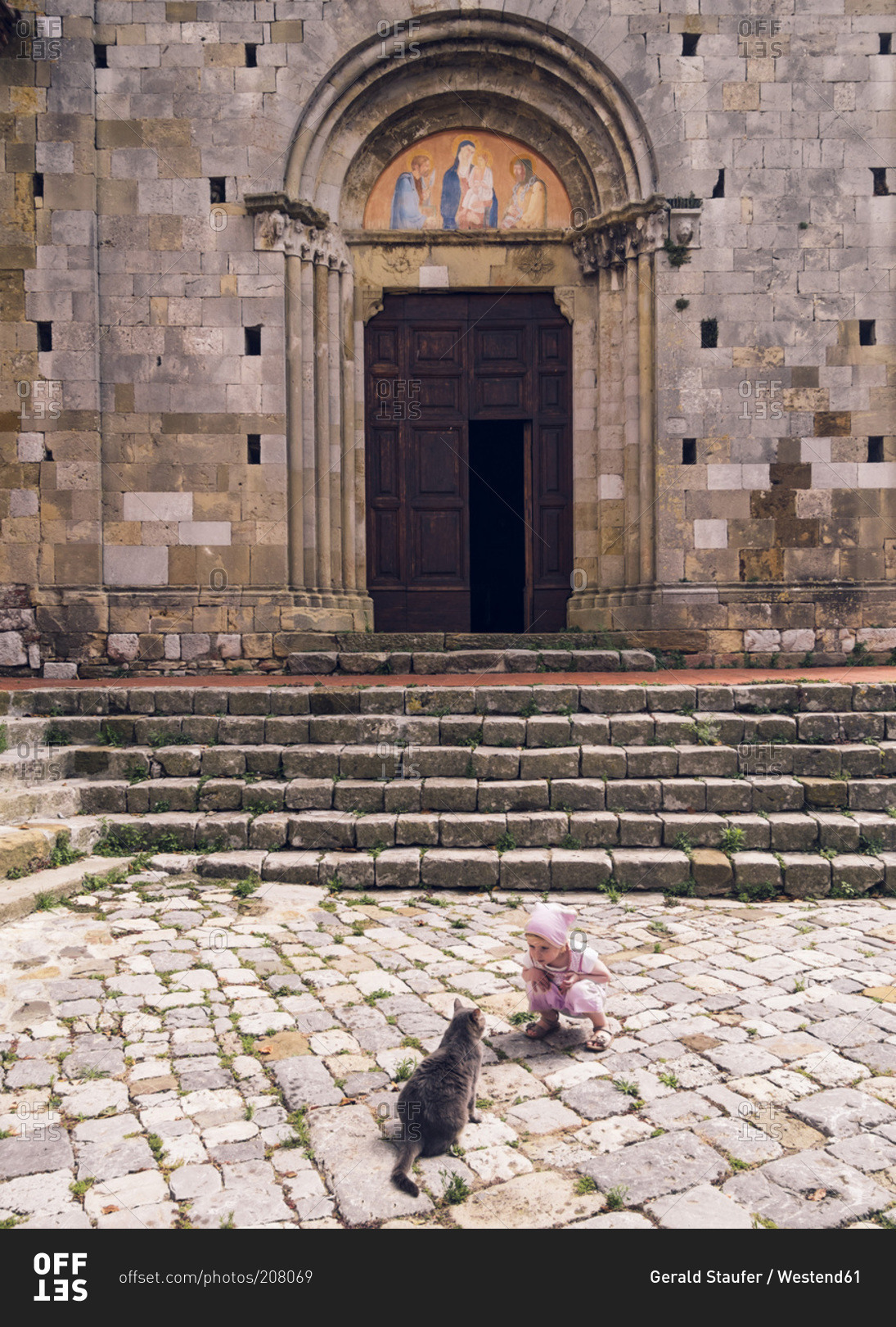 Girl and cat in front of a church