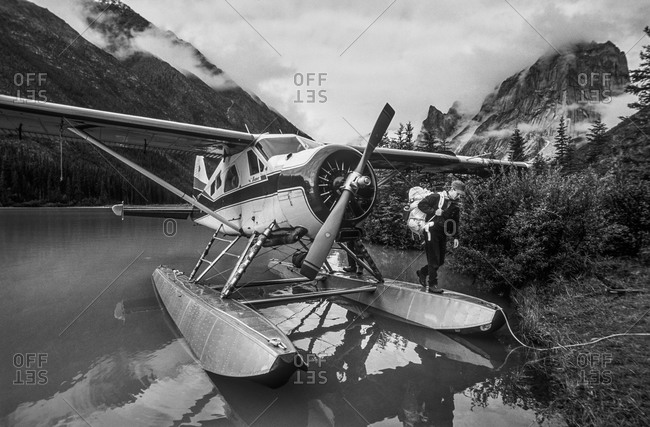 Climber unloads equipment from plane in Canadian mountains