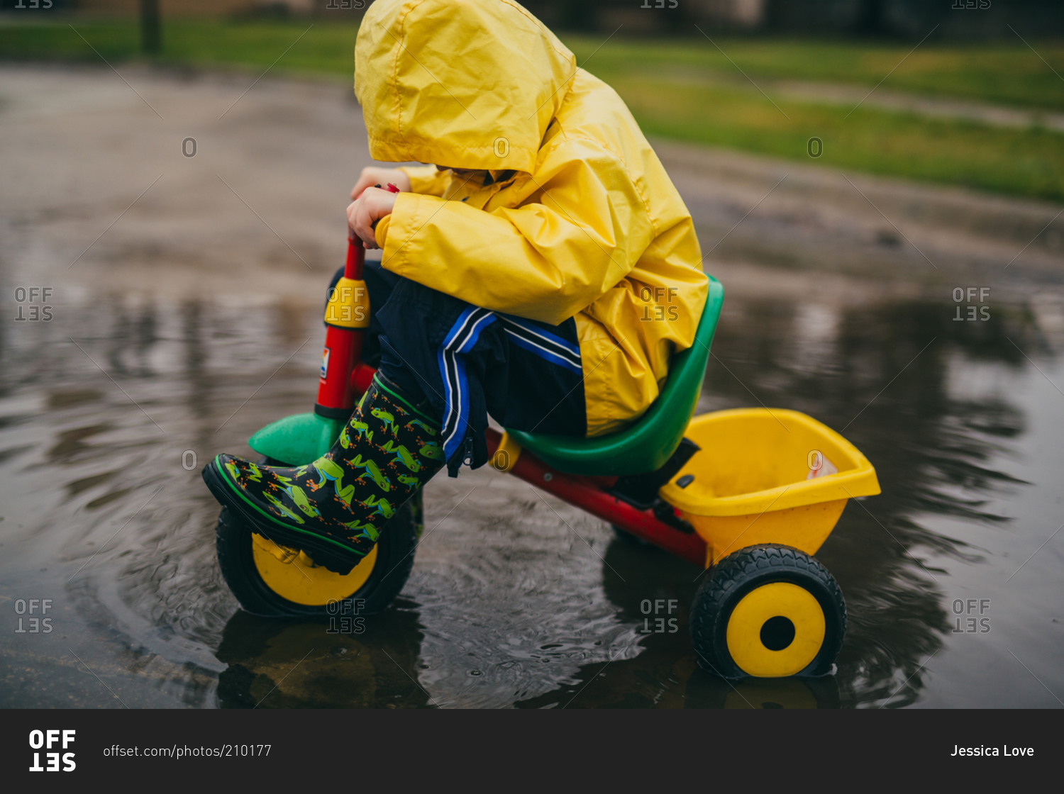 boy-riding-a-bike-in-a-puddle-stock-photo-offset