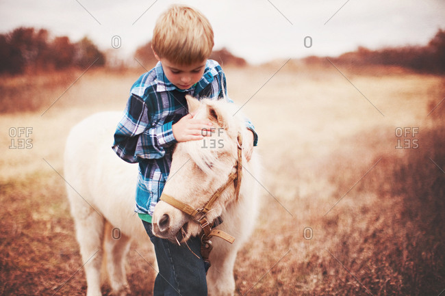 Boy petting a pony