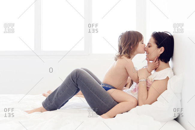 Little Girl Kissing Her Mother In A Bed Stock Photo Offset