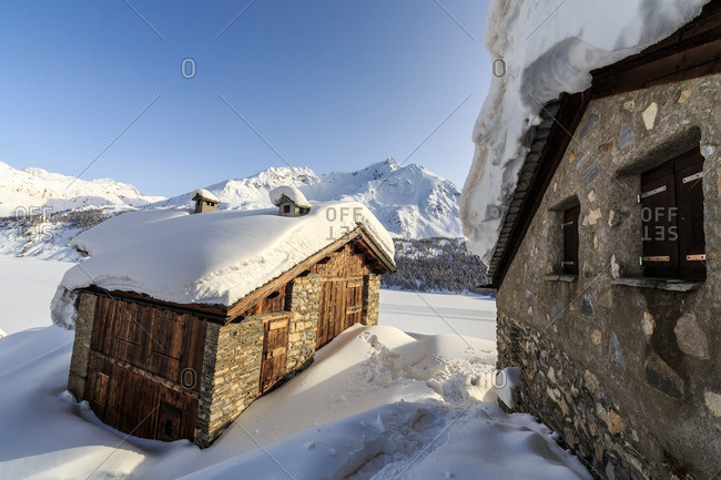 A typical hut covered with snow at the Maloja Pass, Graubunden, Swiss Alps, Switzerland, Europe