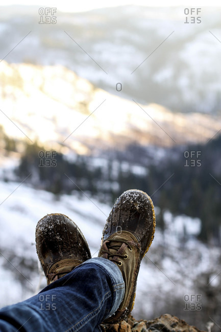 Woman's feet in  hiking boots against Idaho's Rocky Mountains