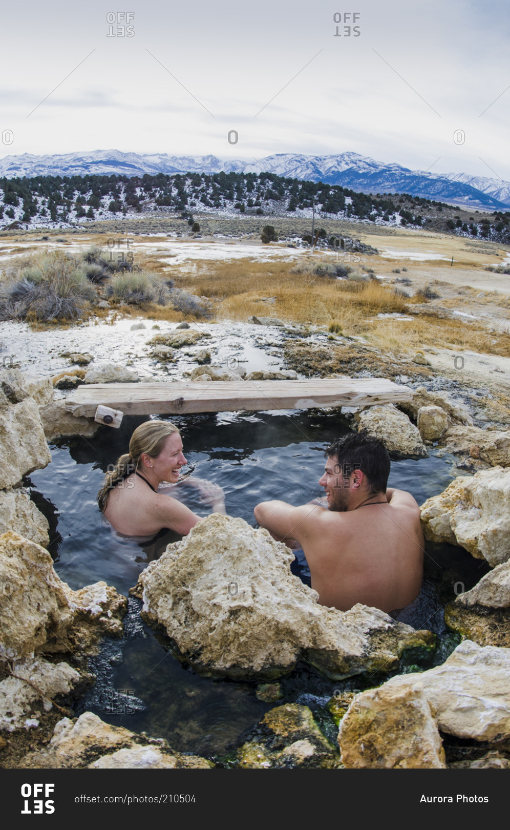 Couple soaks in winter at Travertine Hot Springs, Eastern Sierras, California