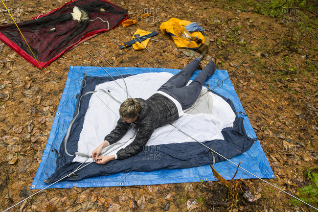 Woman lays down to set up tent in Montana