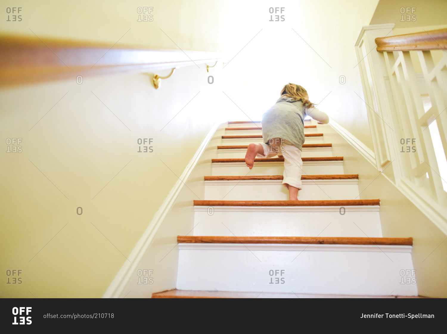 Young girl walking upstairs at home stock photo - OFFSET