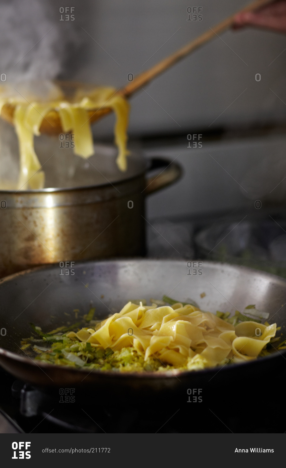 Cooked pasta being added to a skillet