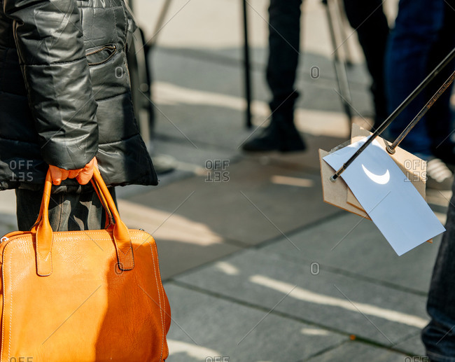 Person using camera obscura to project an image of solar eclipse onto paper