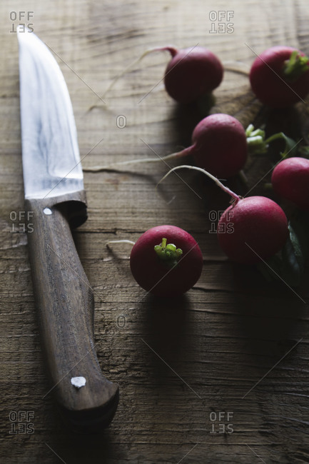 Radishes on a cutting board with a knife