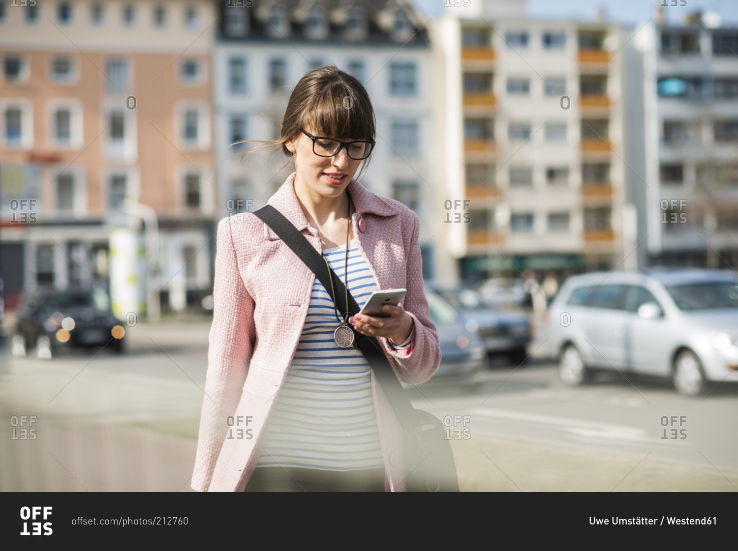 Young Woman Holding Phone Walking On Street High-Res Stock Photo