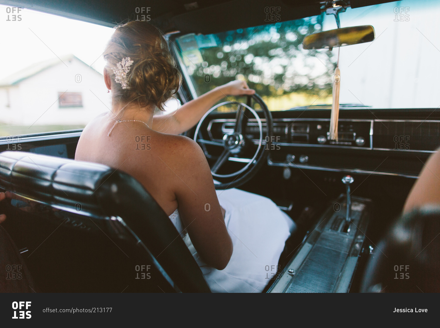 A bride drives a vintage car stock photo - OFFSET