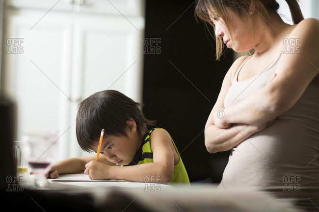 Mom Looks On Son Doing His Japanese Homework Stock Photo OFFSET