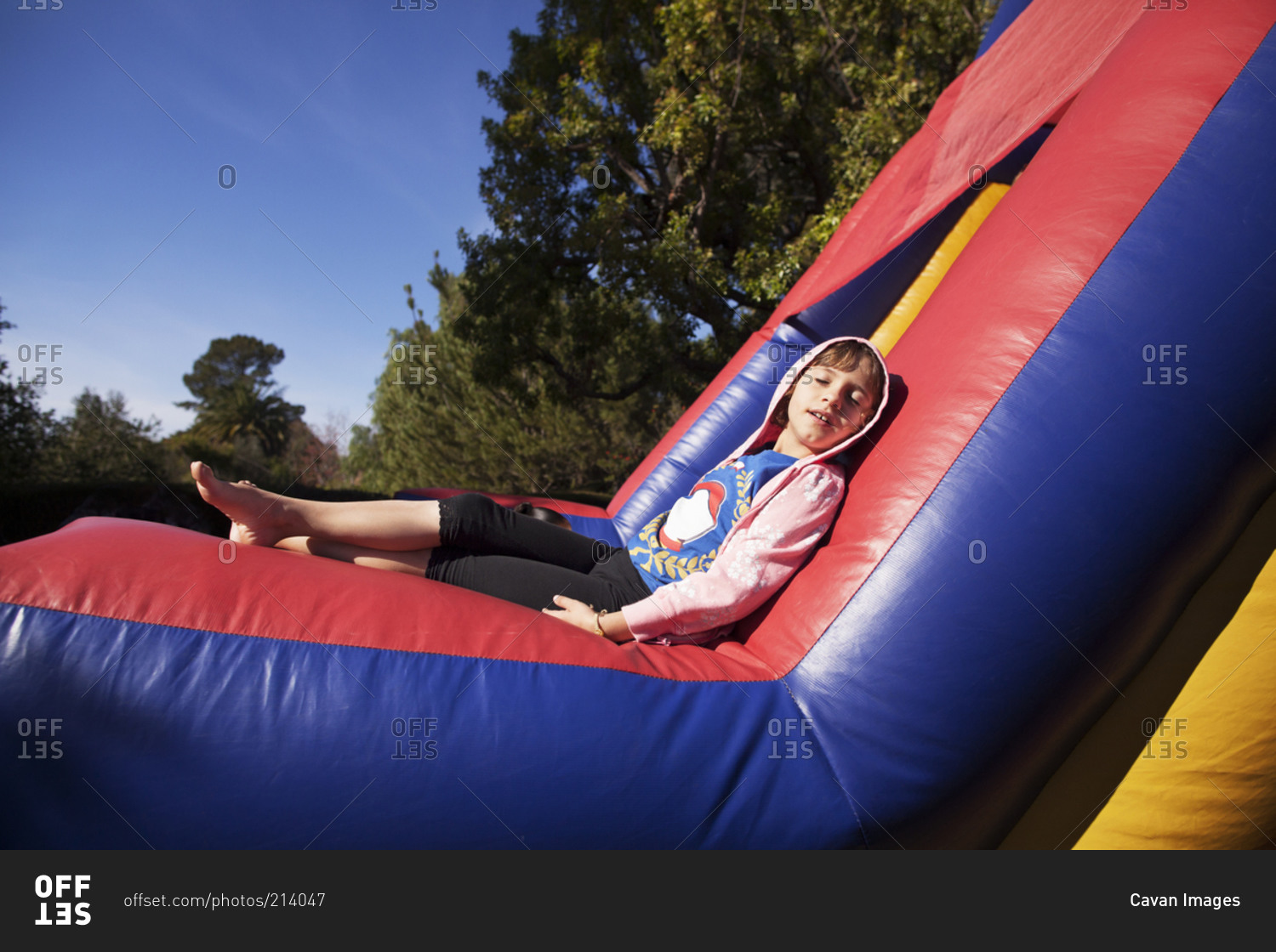 Young girl relaxing in the sun on a bounce house