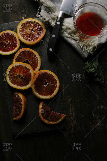 Sliced blood oranges with a knife