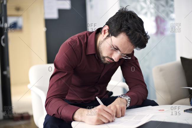 Man talking notes during meeting in office