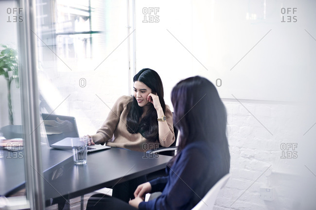 Woman checking laptop during meeting
