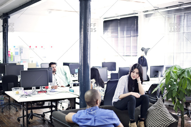 Coworkers casually chatting in office