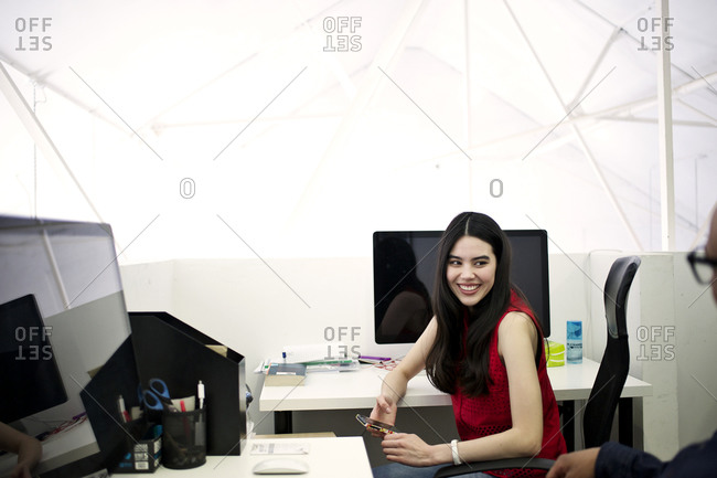 Coworkers in cubicle smiling at each other