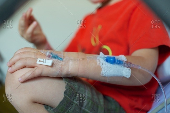 Boy with an IV drip in his hand
