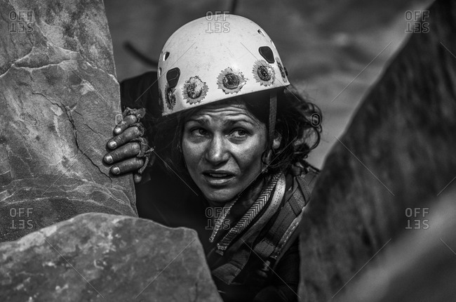 Climber scopes her next move on challenging cliff