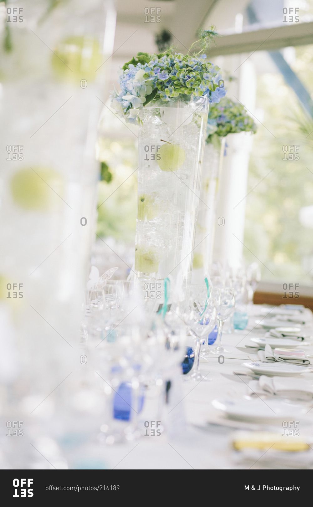 A wedding reception table with tall vases