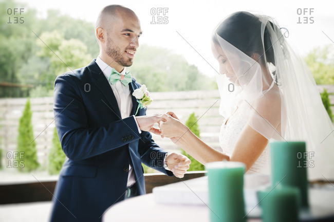 A bride and groom exchange rings at a wedding