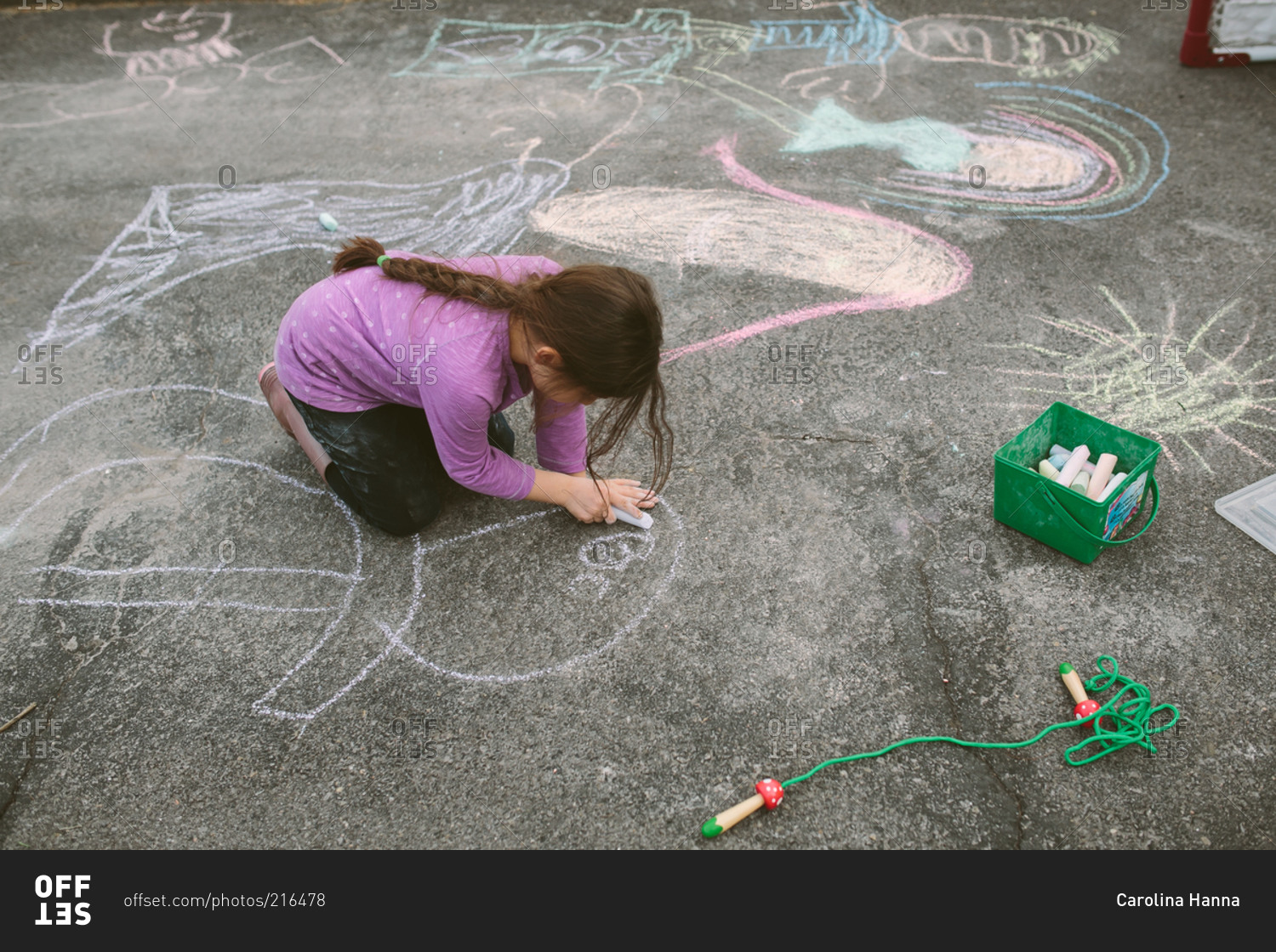 Girl drawing on concrete with sidewalk chalk