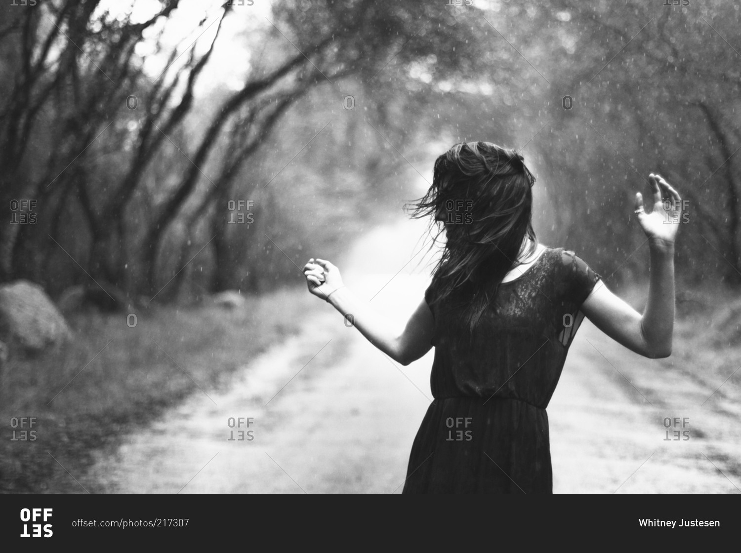 Woman carefree in rain on country road