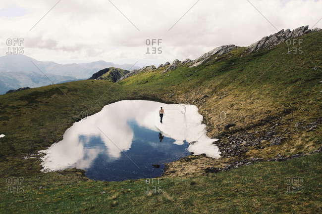 A man stands in the snow of a glacier in the mountains