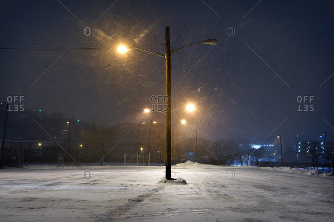 Streetlights in snowy parking lot stock photo - OFFSET