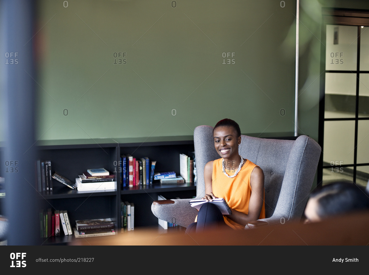 A woman smiles at a colleague in an office common area