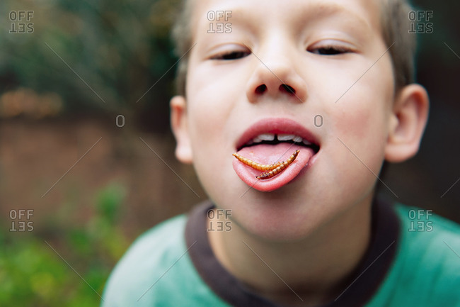 Close up of a boy's face with larva on his tongue
