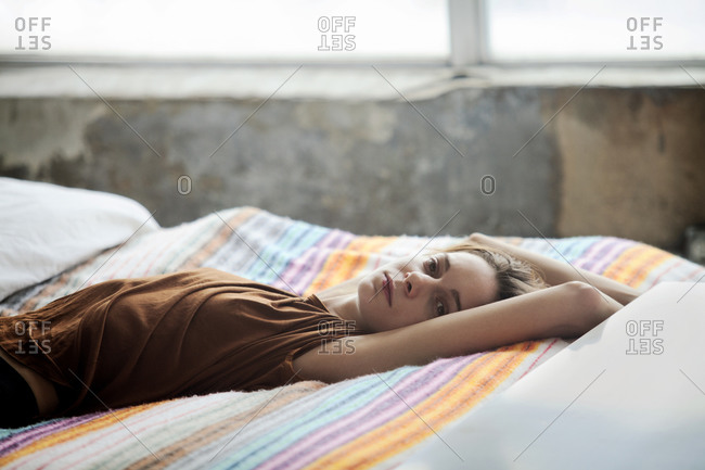 Woman lying on bed in loft