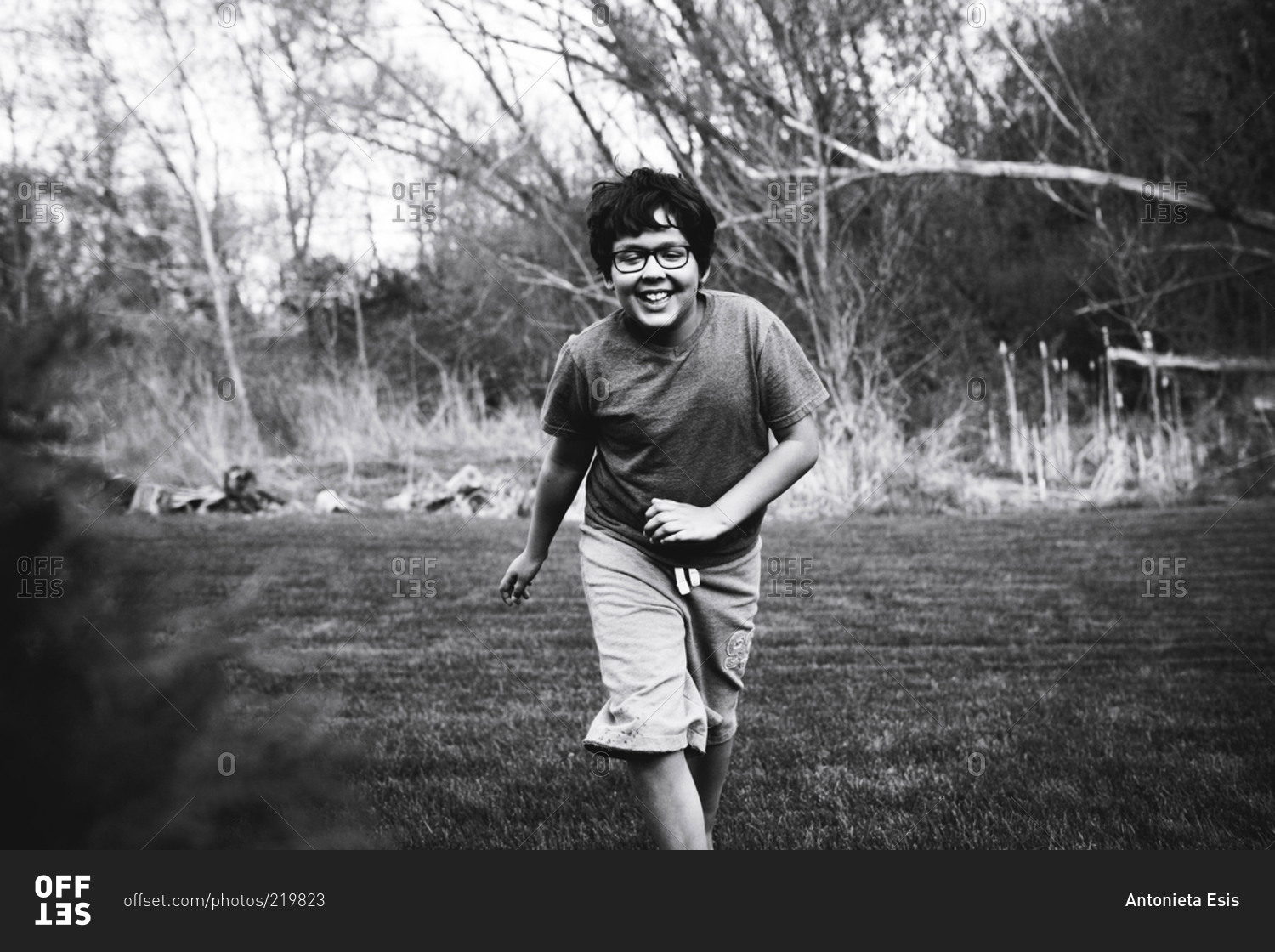 Boy runs through the grass, black and white