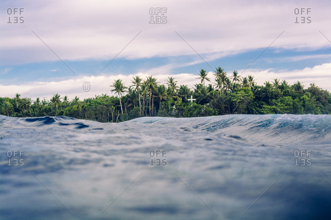 Cross in the jungle seen from the ocean. Siargao, Philippines