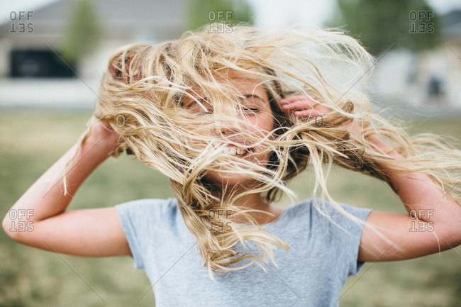 Girl flipping her hair around stock photo - OFFSET