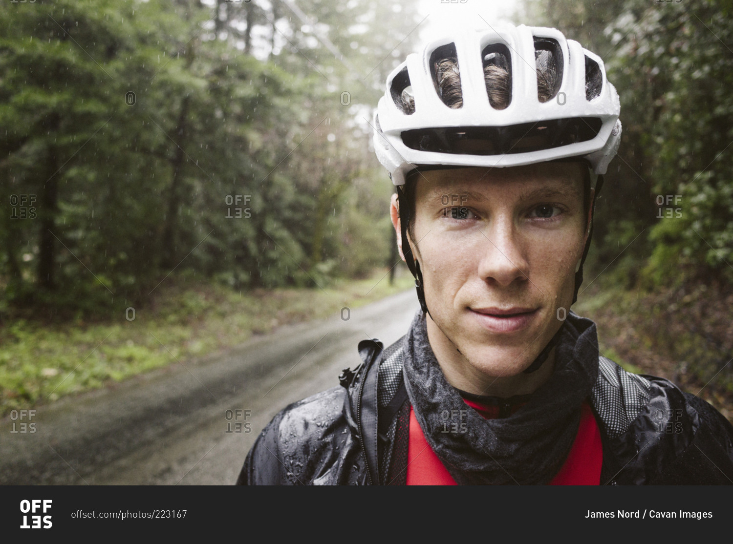 A cyclist standing in the rain
