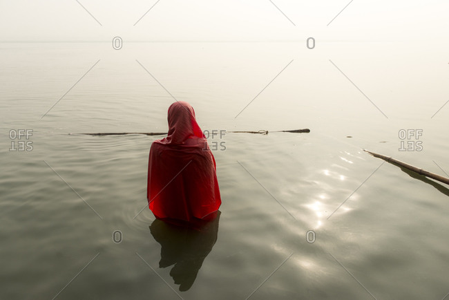 A woman cleanses herself in the waters of the Ganges River in Varanasi, India