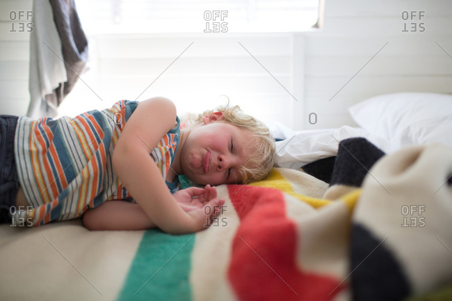 Boy lying on bed making goofy face