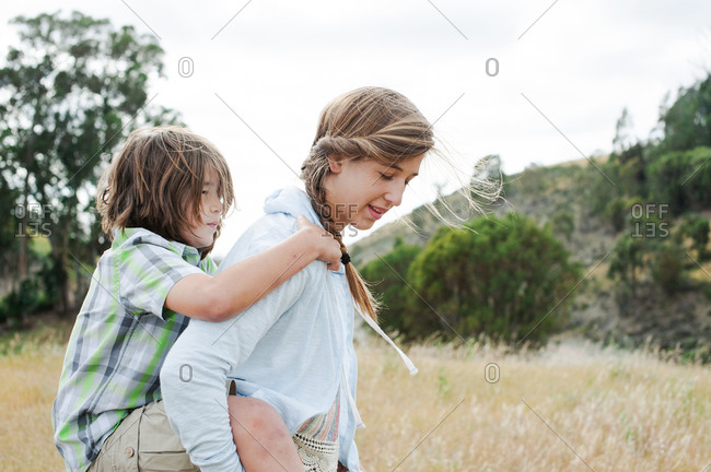 Young girl carrying sister giving piggyback ride Stock Photo