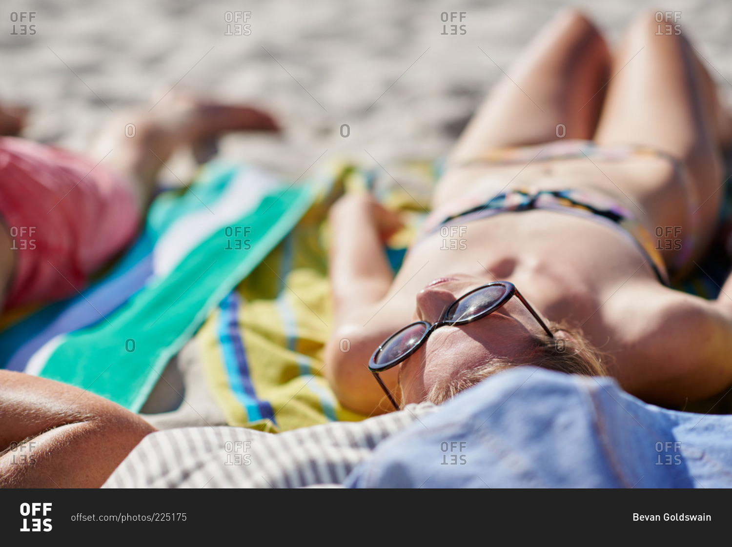 Woman facing the sun and tanning on the beach