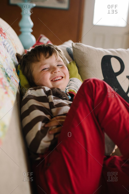 Grinning boy lounging on couch