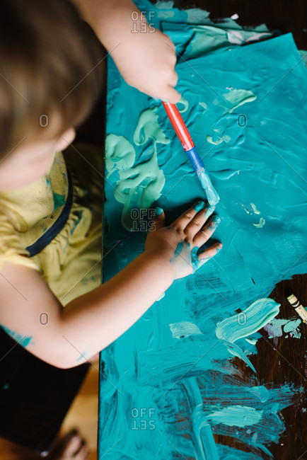 Girl making paint mess on table